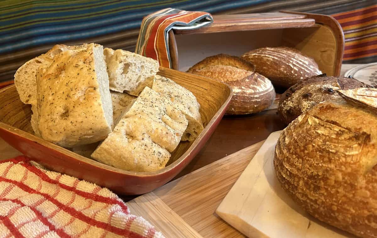 Sliced focaccia and boules of dark bread